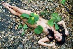 Обнаженная девушка, прикрытая листьями